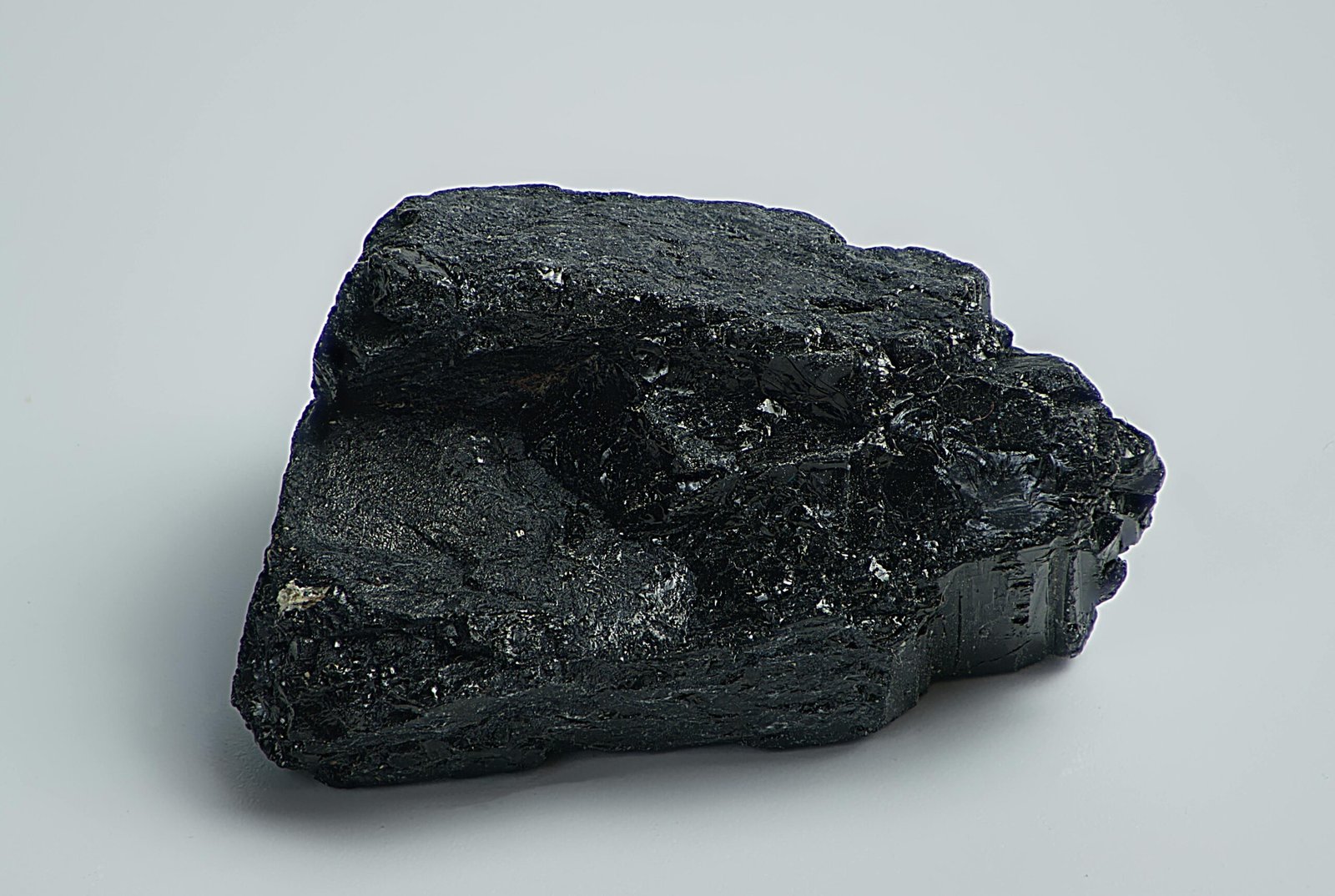 4. Janko Đonović: Pjesnik socijalne istine Detailed macro shot of a black mineral rock on a plain surface, showcasing texture and natural form.