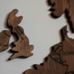 Close-up of wooden puzzle pieces shaped like the UK and Ireland on a white background.